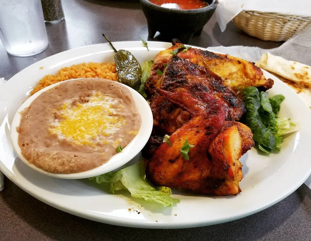 Mexican mixed grill platter with roasted chicken, grilled steak, rice, refried beans, roasted peppers, lettuce, and tortillas