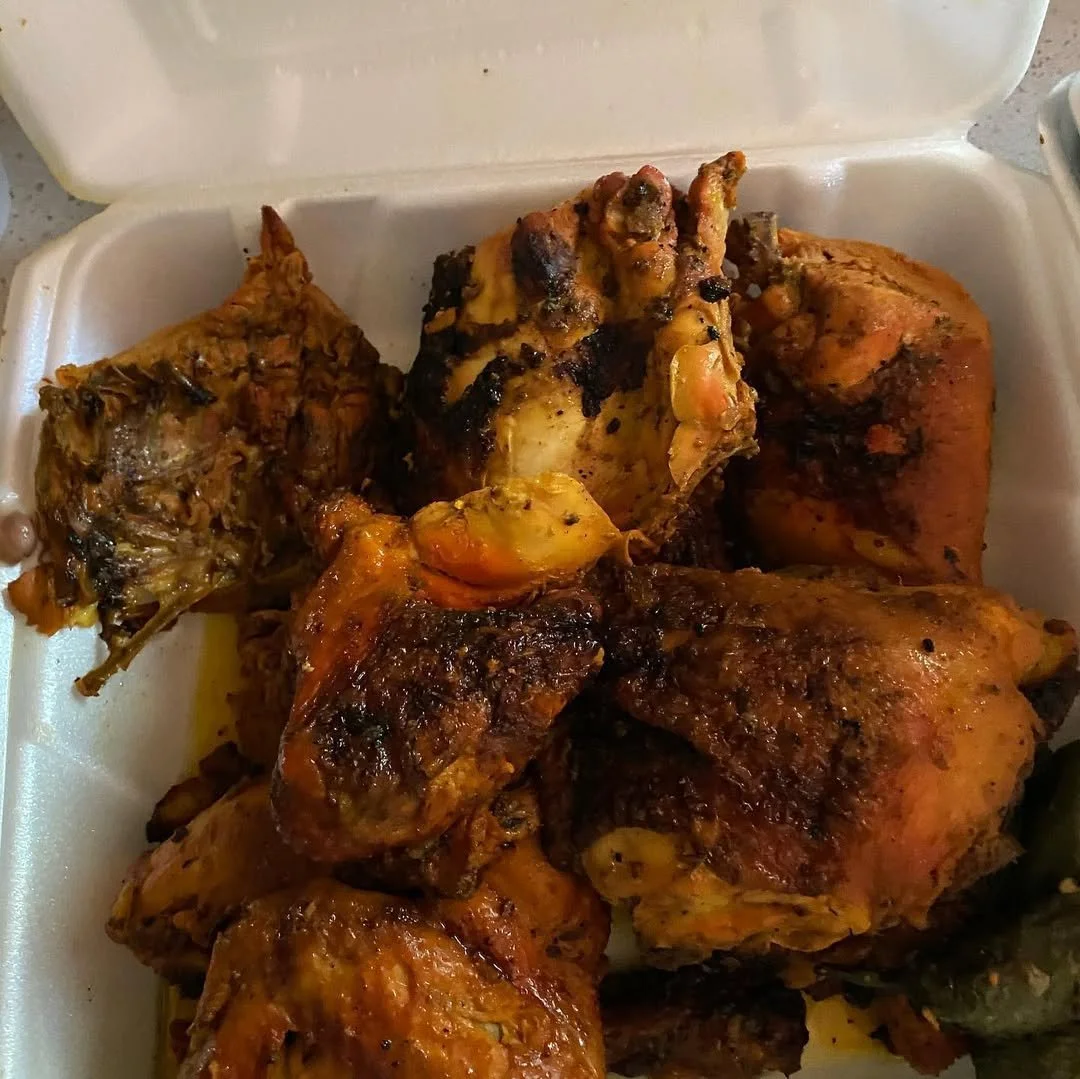 Assorted grilled and roasted chicken pieces in a foam takeout container