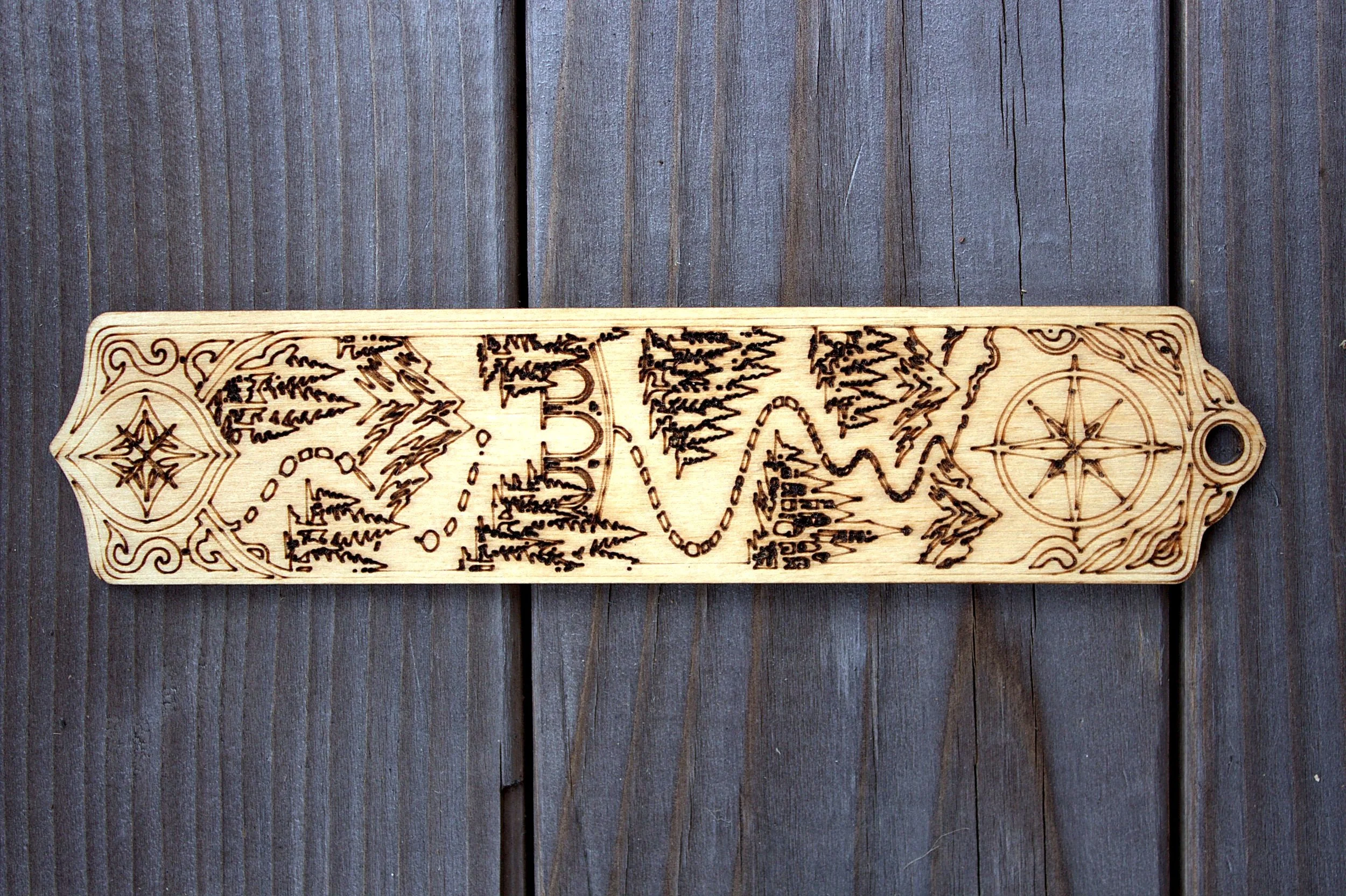 Laser-engraved bookmark — compass and river valley design