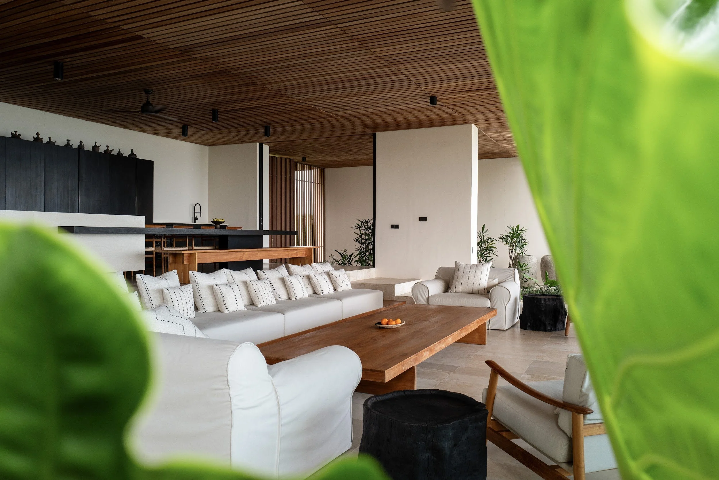The living space. Pocket doors open the living room to the sea breeze, with air conditioning whenever you want it. The indoor dining table seats 10, and deep, generous couches leave room for everyone to unwind.