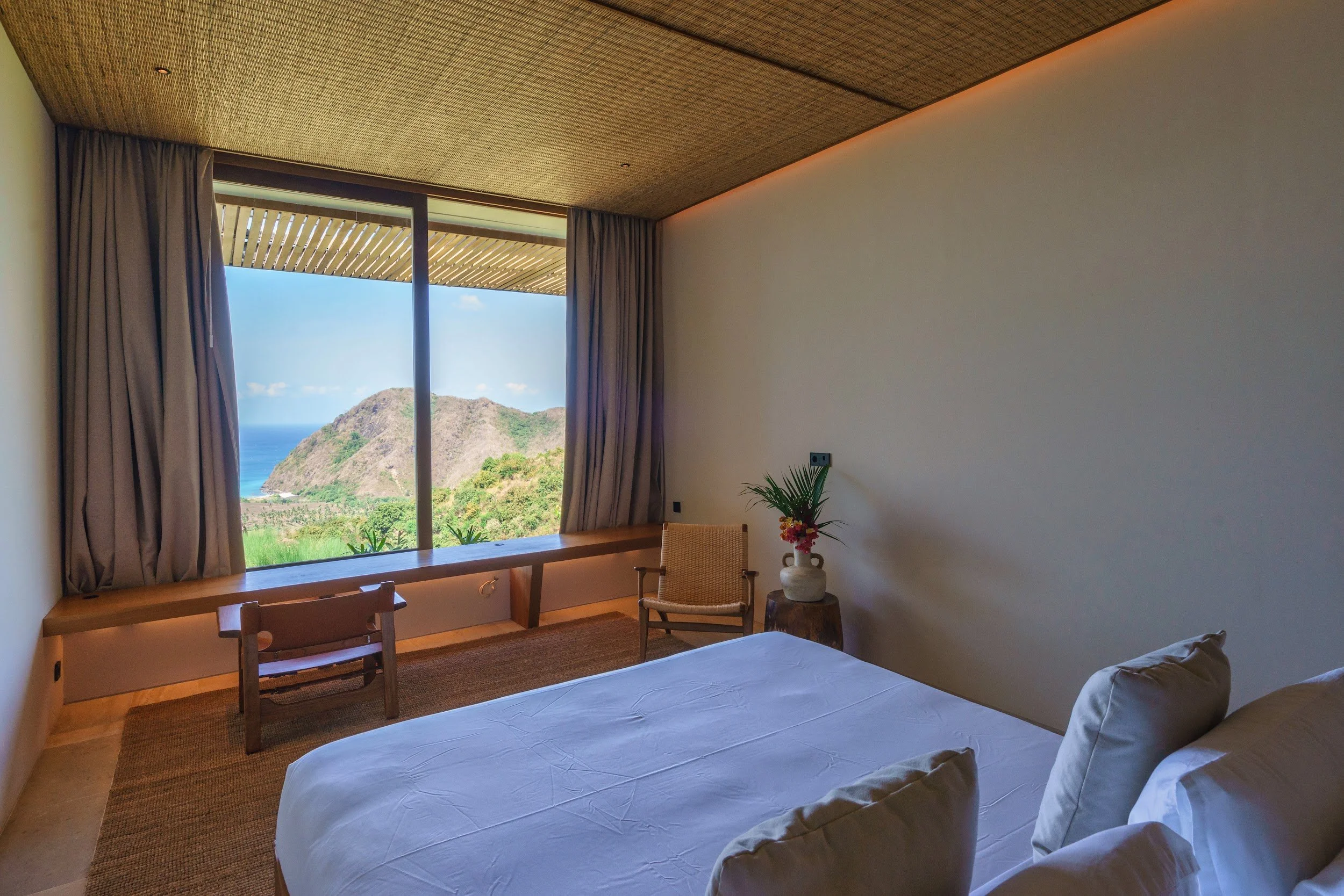 King bed in Bedroom 3 at Villa Kai Lani with a window view over the hills to the sea