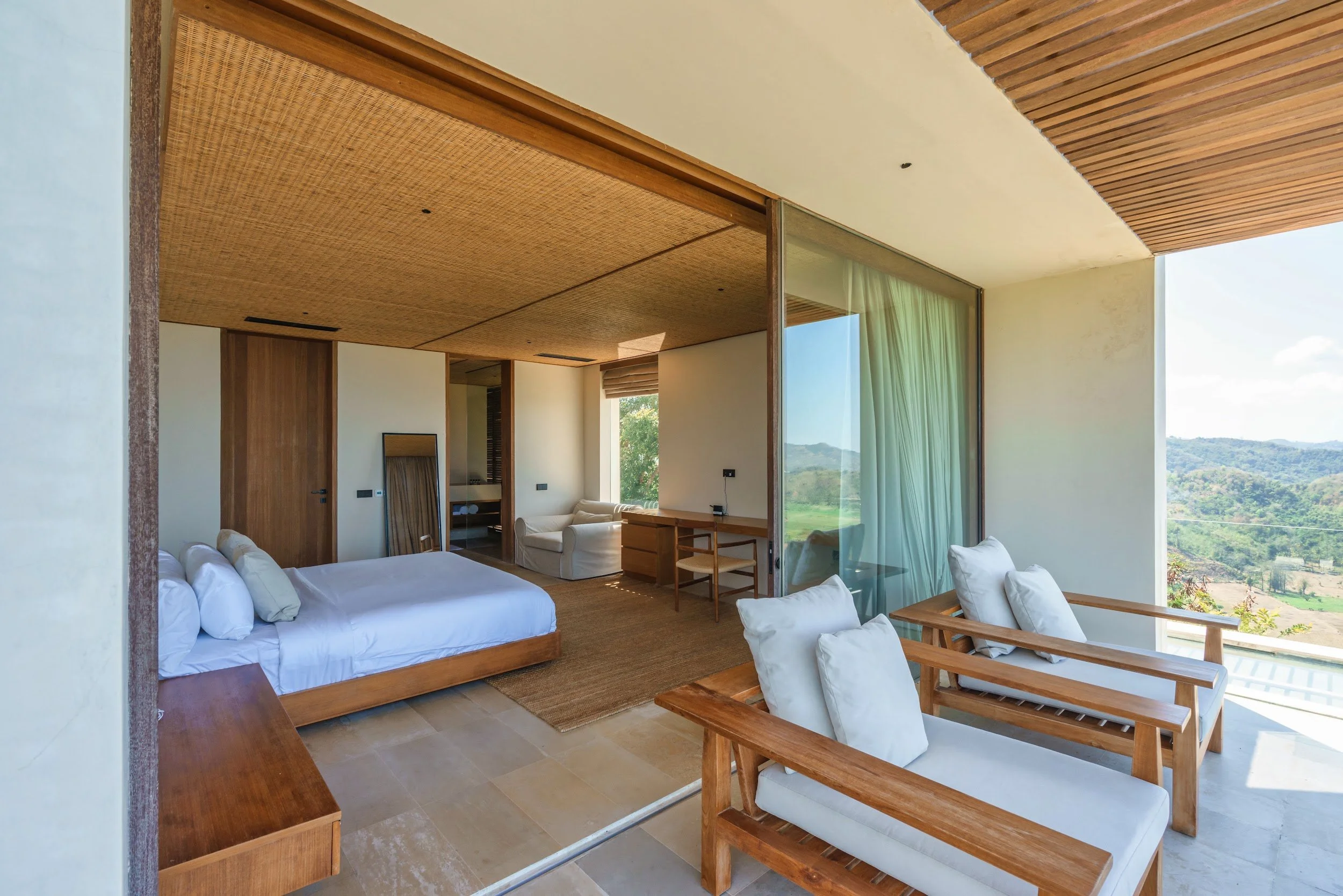 Primary suite at Villa Kai Lani with a king bed opening onto a terrace with lounge chairs