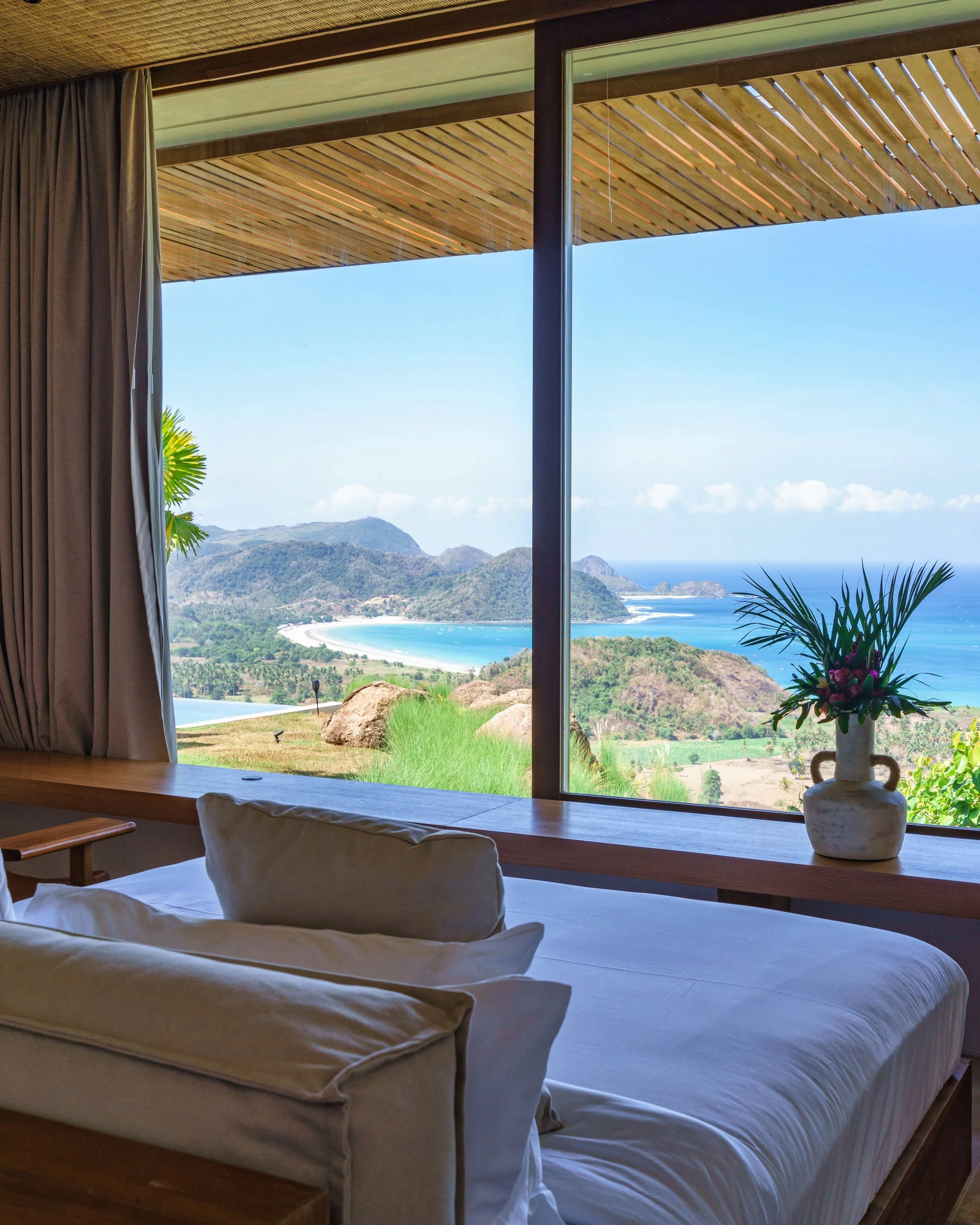 Wide window in Bedroom 2 framing Selong Belanak Bay at Villa Kai Lani