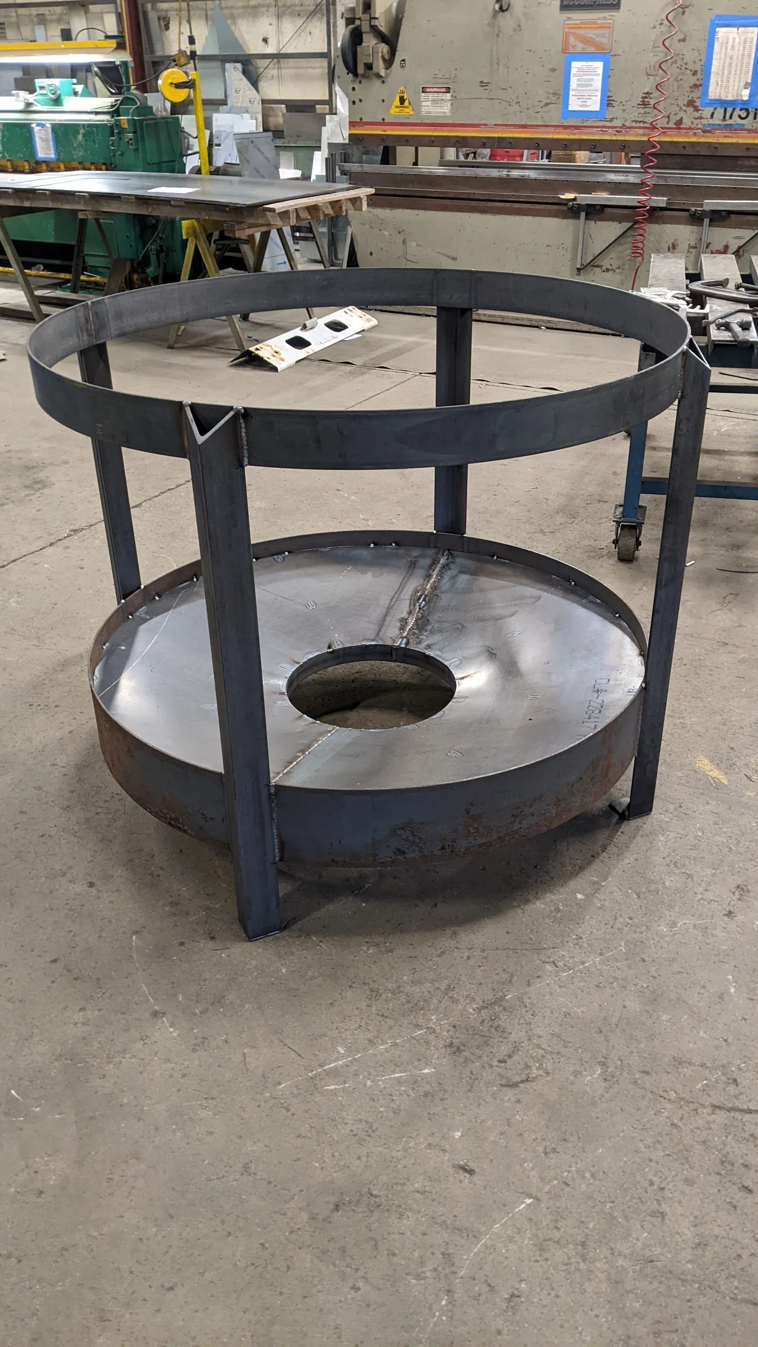 Welded steel cylindrical tank frame under construction in a metal fabrication workshop