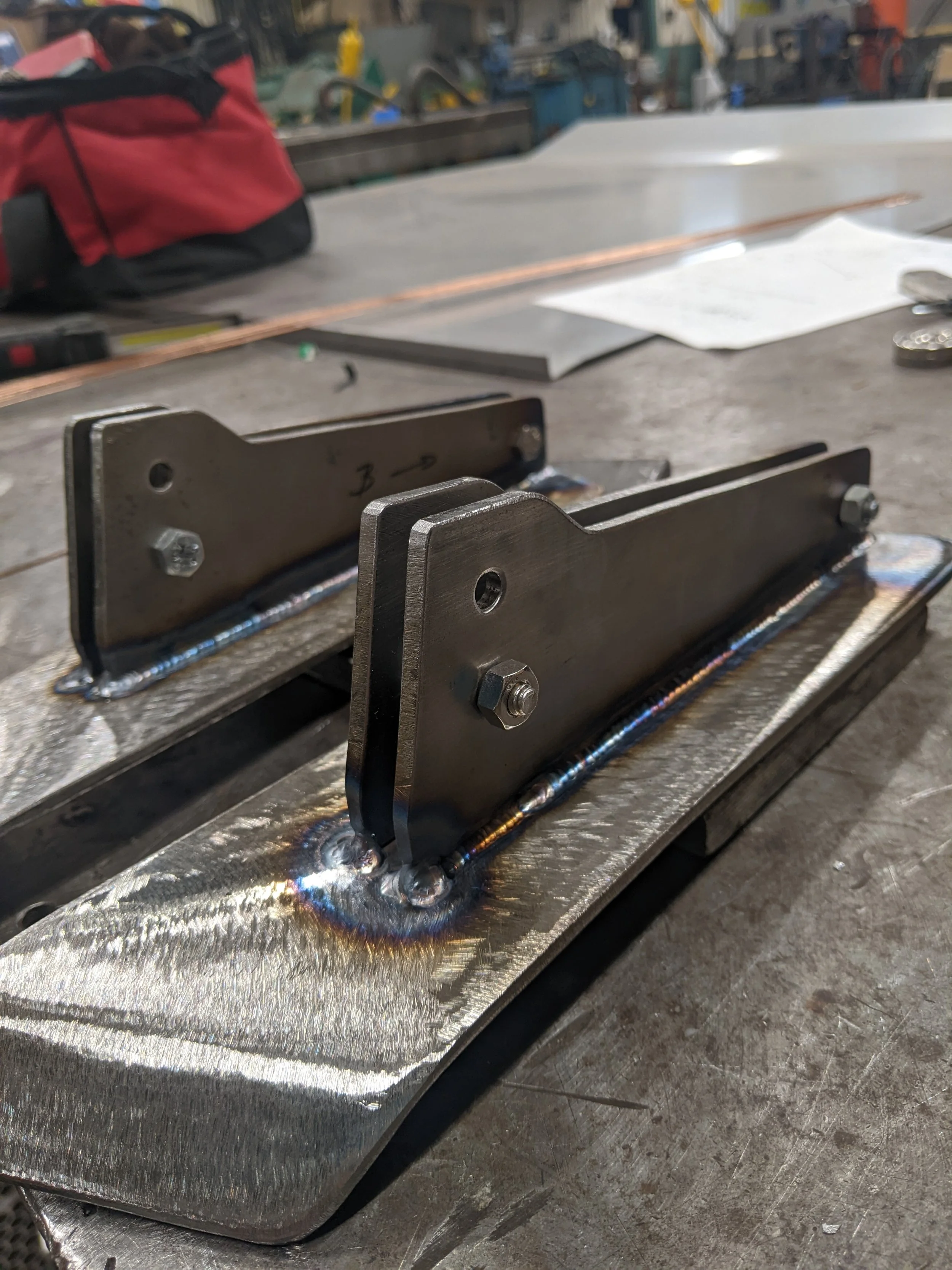 Close-up of welded steel brackets and supports on a metal fabrication workbench