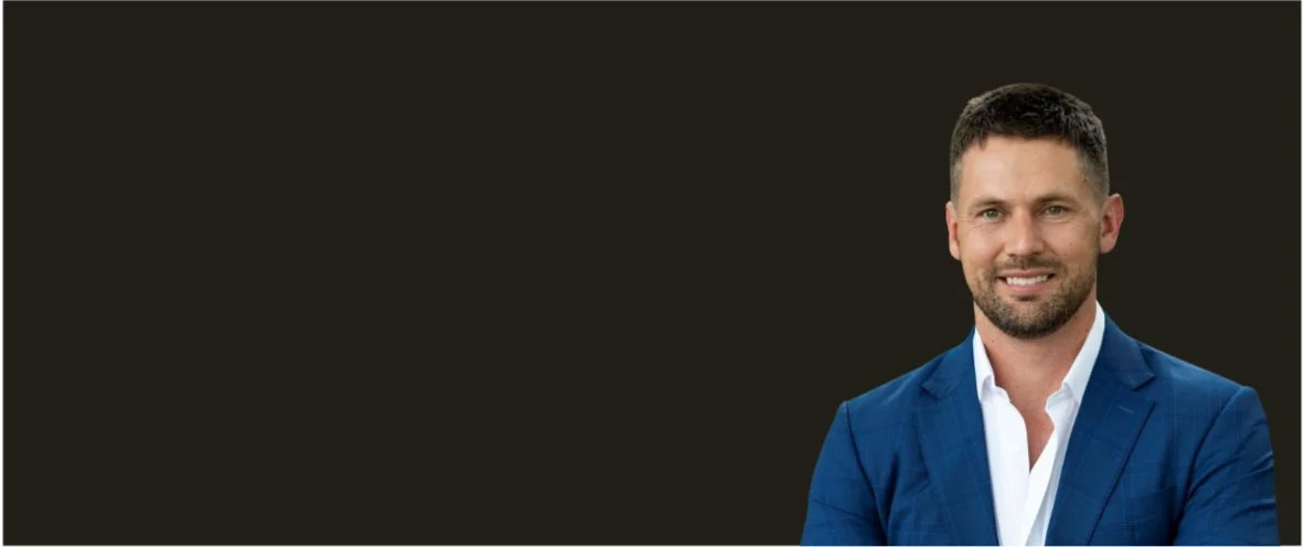 Professional man in a blue suit and white shirt against a dark background