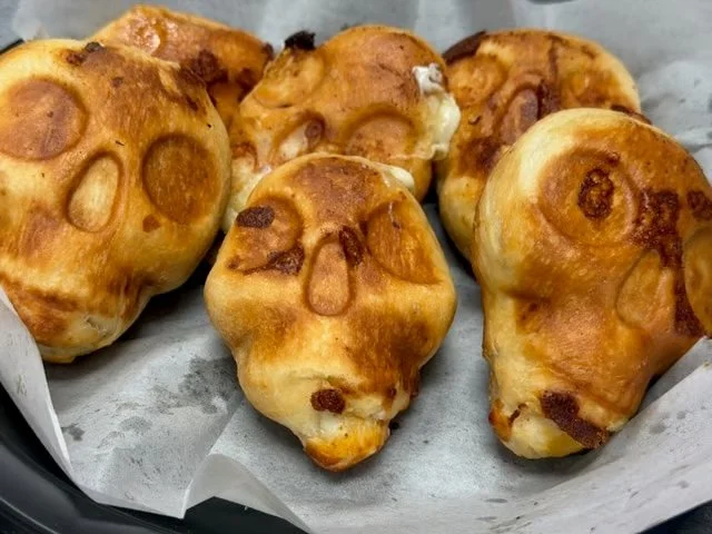Freshly baked golden-brown raisin buns arranged on parchment paper