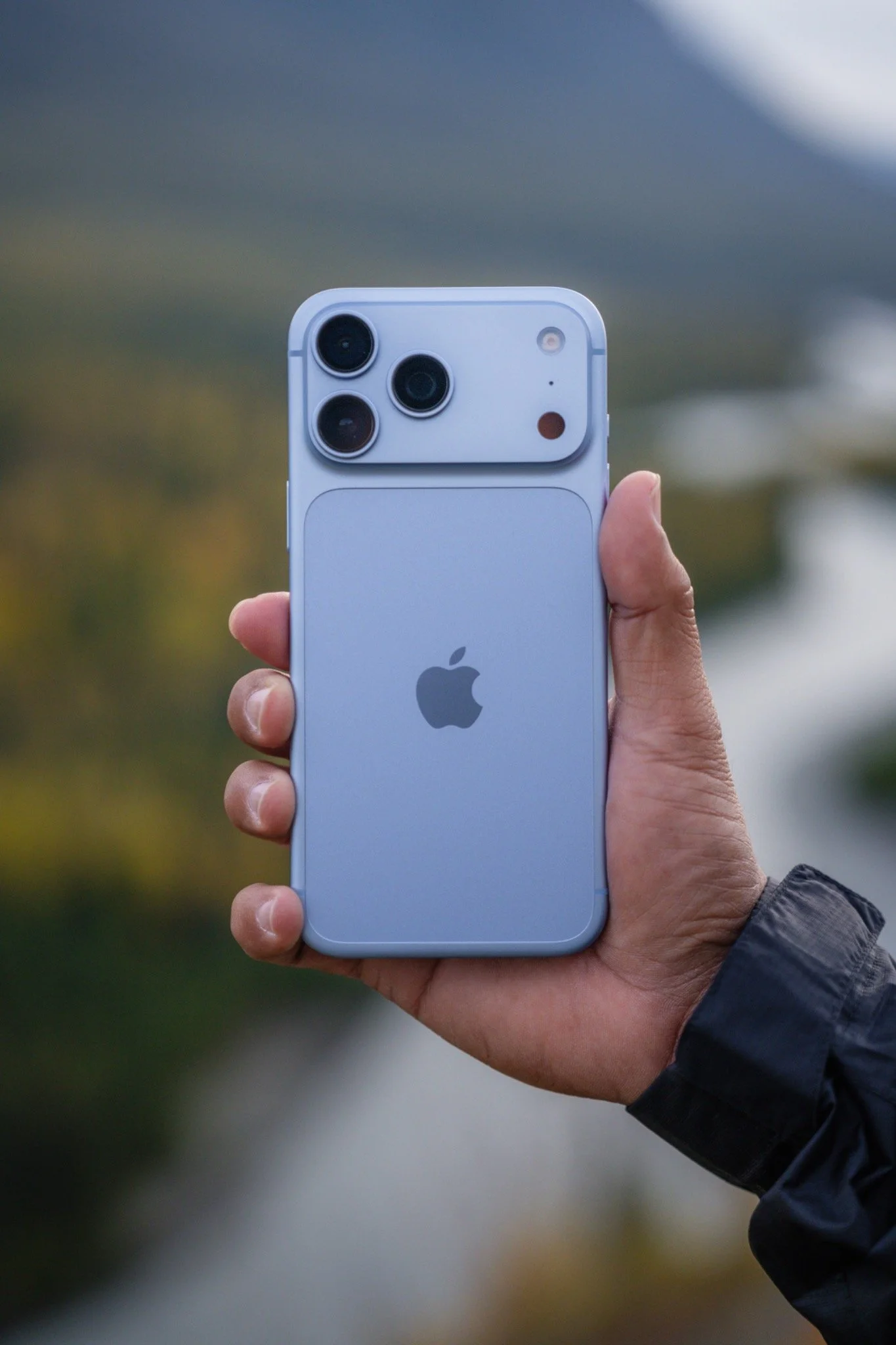 Behind the scenes: iPhone held against an Alaska landscape