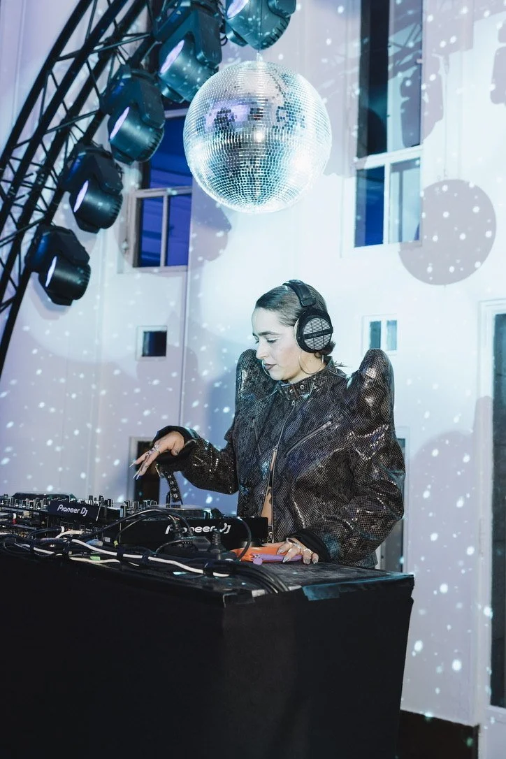 A DJ beneath a mirror ball