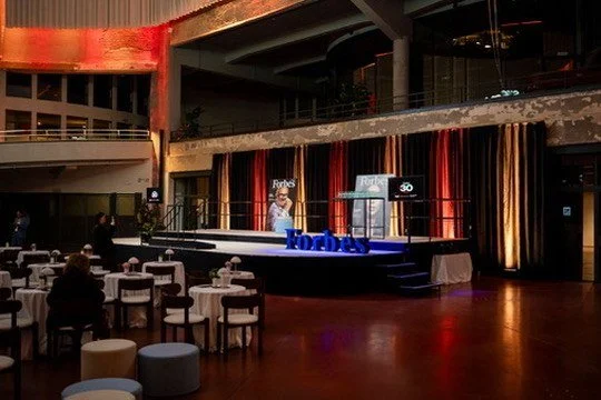 The Forbes stage framed by velvet curtains
