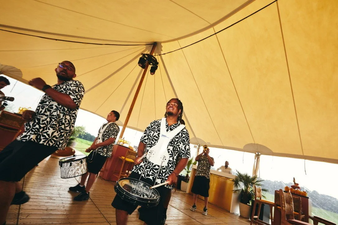 Drummers marching through the yellow tent