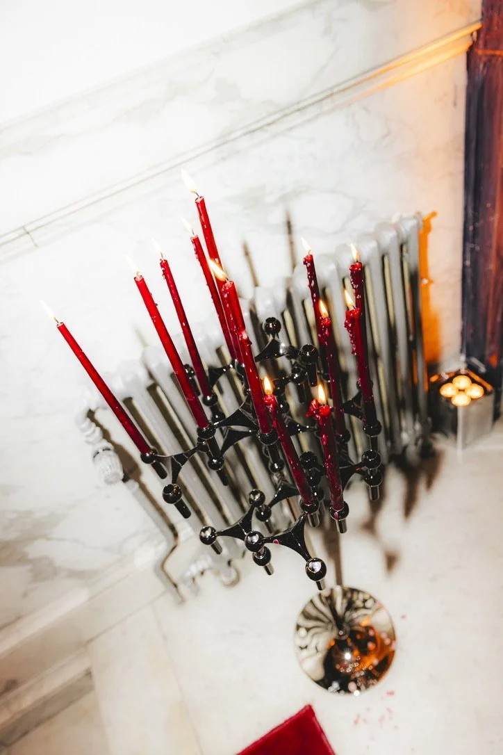 A sculptural candelabra with red dripping candles