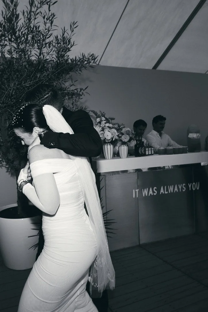 Black-and-white: the couple embracing at a bar reading It was always you