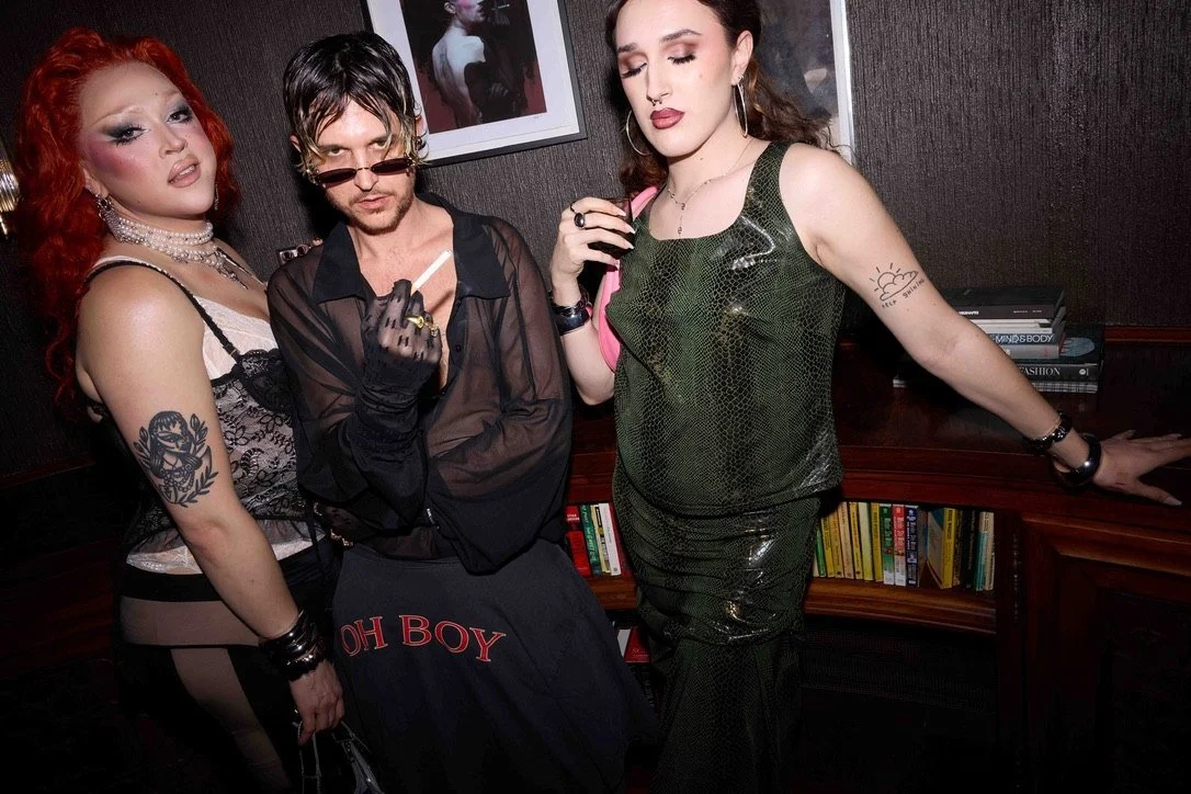 Max Colombie with two guests in front of the bookshelves