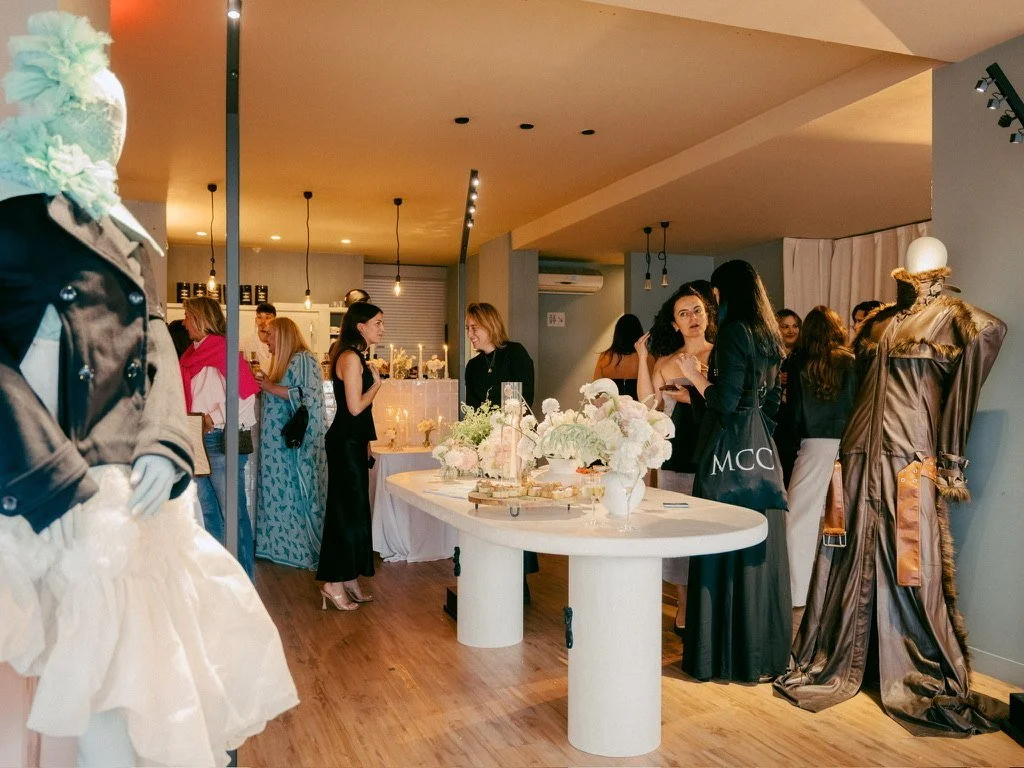Guests mingling in the ELLE Fashion Café between couture mannequins and a white table with flowers