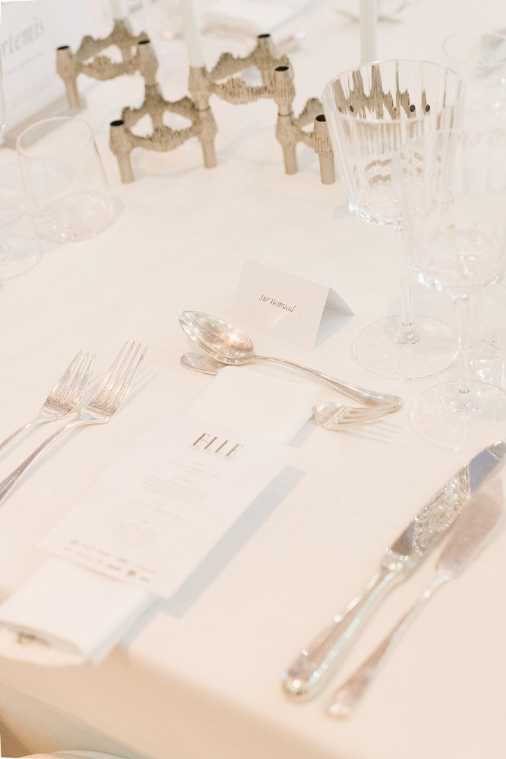 A place setting with an ELLE menu and silver cutlery