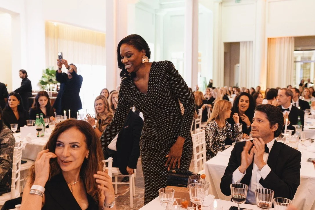 An award winner rises to applause between the dinner tables