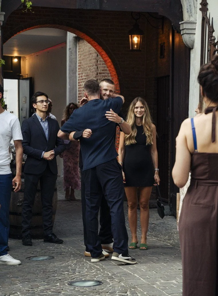 Jan welcoming a guest with a hug at the entrance arch