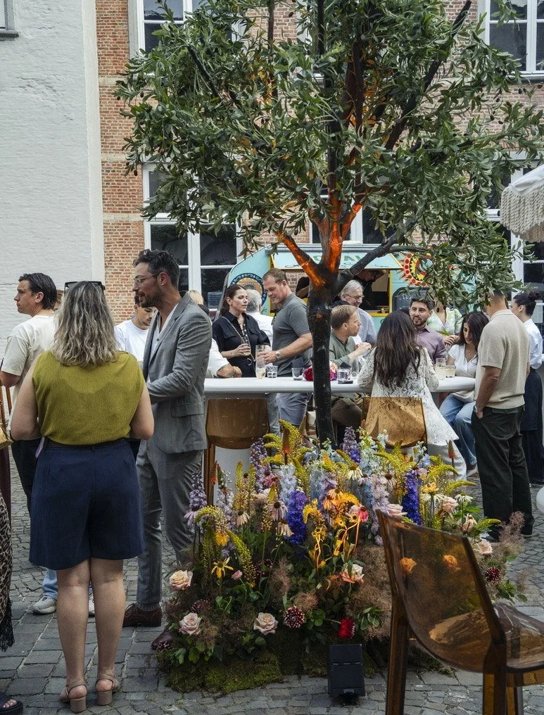 An olive tree rising from a meadow of flowers among the guests at Jacques
