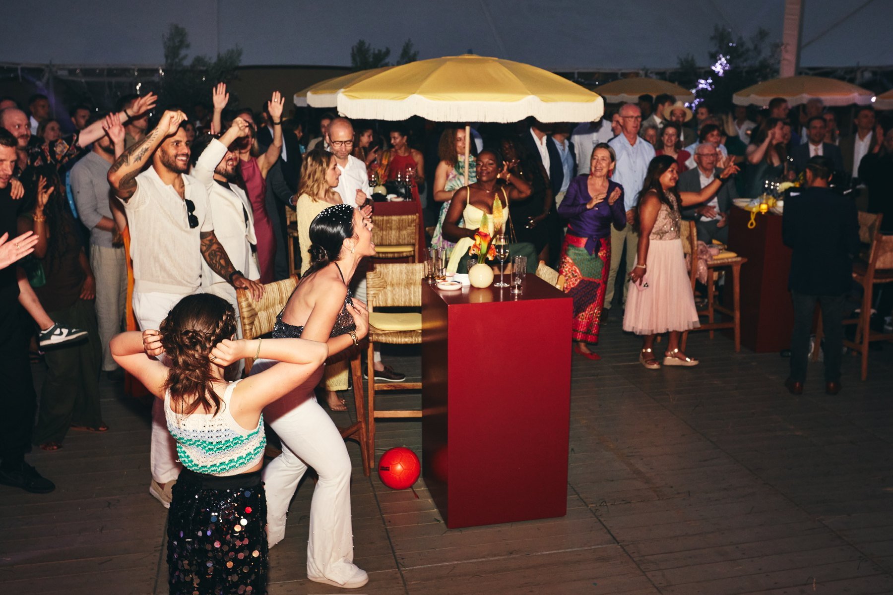 A dance floor at night under yellow fringed parasols