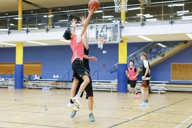 A Cobra goes up at the rim while a defender walls up straight