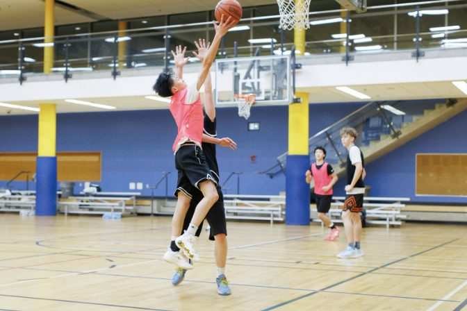 A Cobra goes up at the rim while a defender walls up straight