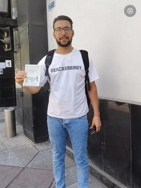 Ein Mann hält ein Dokument in die Kamera.