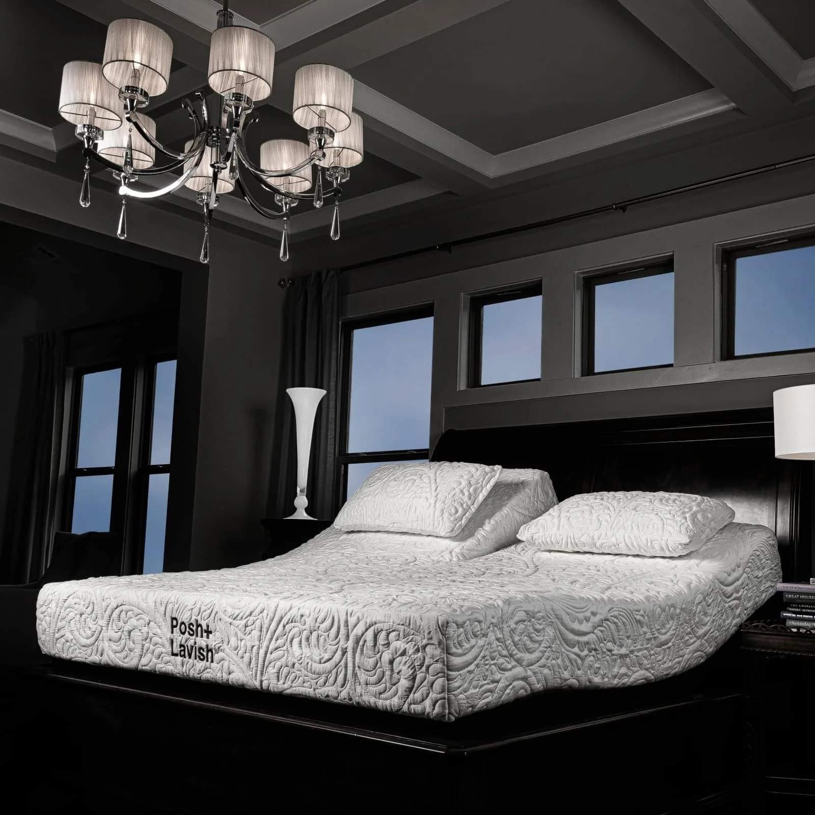 Posh+Lavish mattress with a white quilted cover and pillows on an adjustable base in a dark bedroom with a chandelier