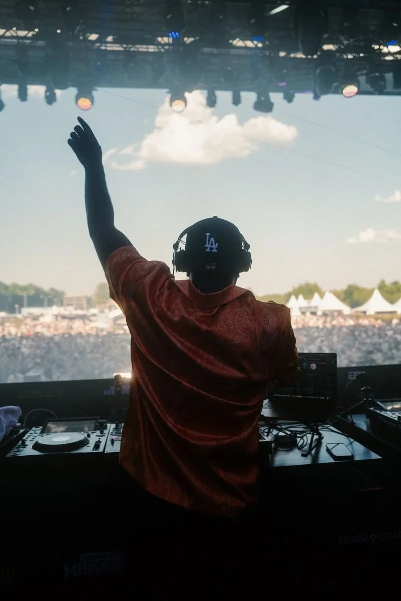 Frizzo mit erhobenem Arm vor einer riesigen Festivalcrowd bei Sonne