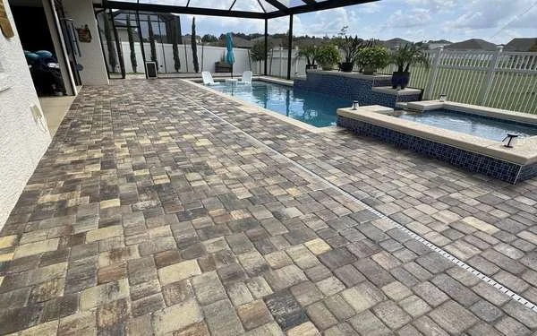 Clean paver pool deck inside a screened pool cage