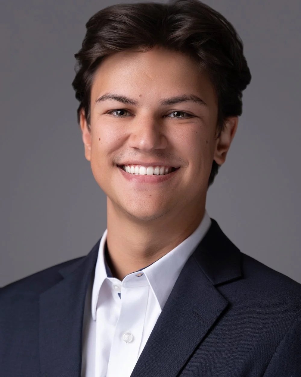 Studio portrait of a team member on a grey background.
