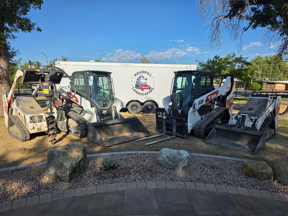 Roadkill's Bobcat loaders lined up in front of the company trailer
