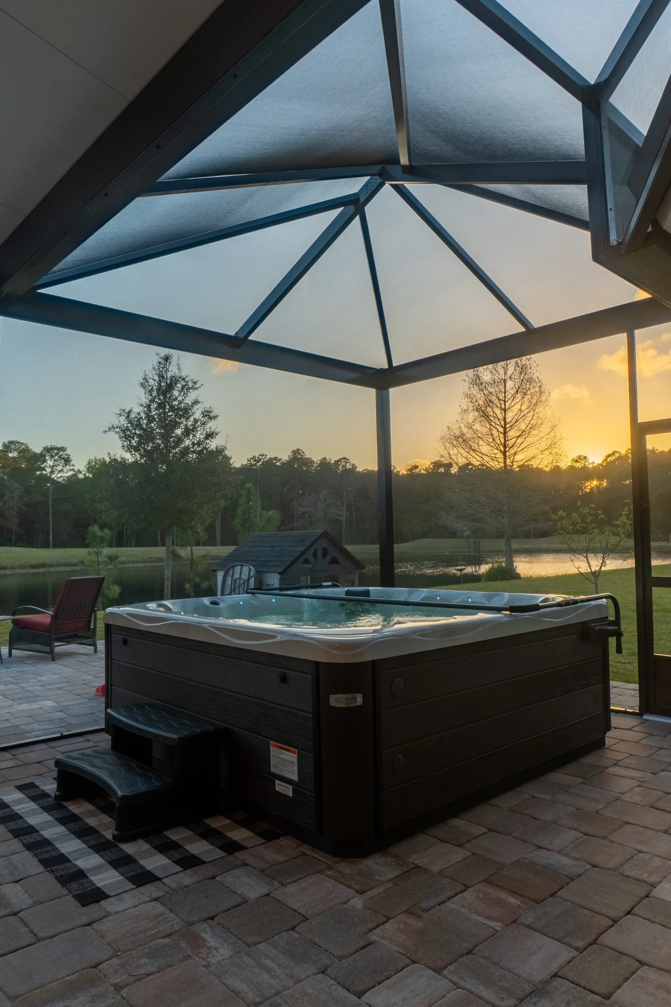 Screen room with a hot tub pad at sunset in Julington Creek Plantation