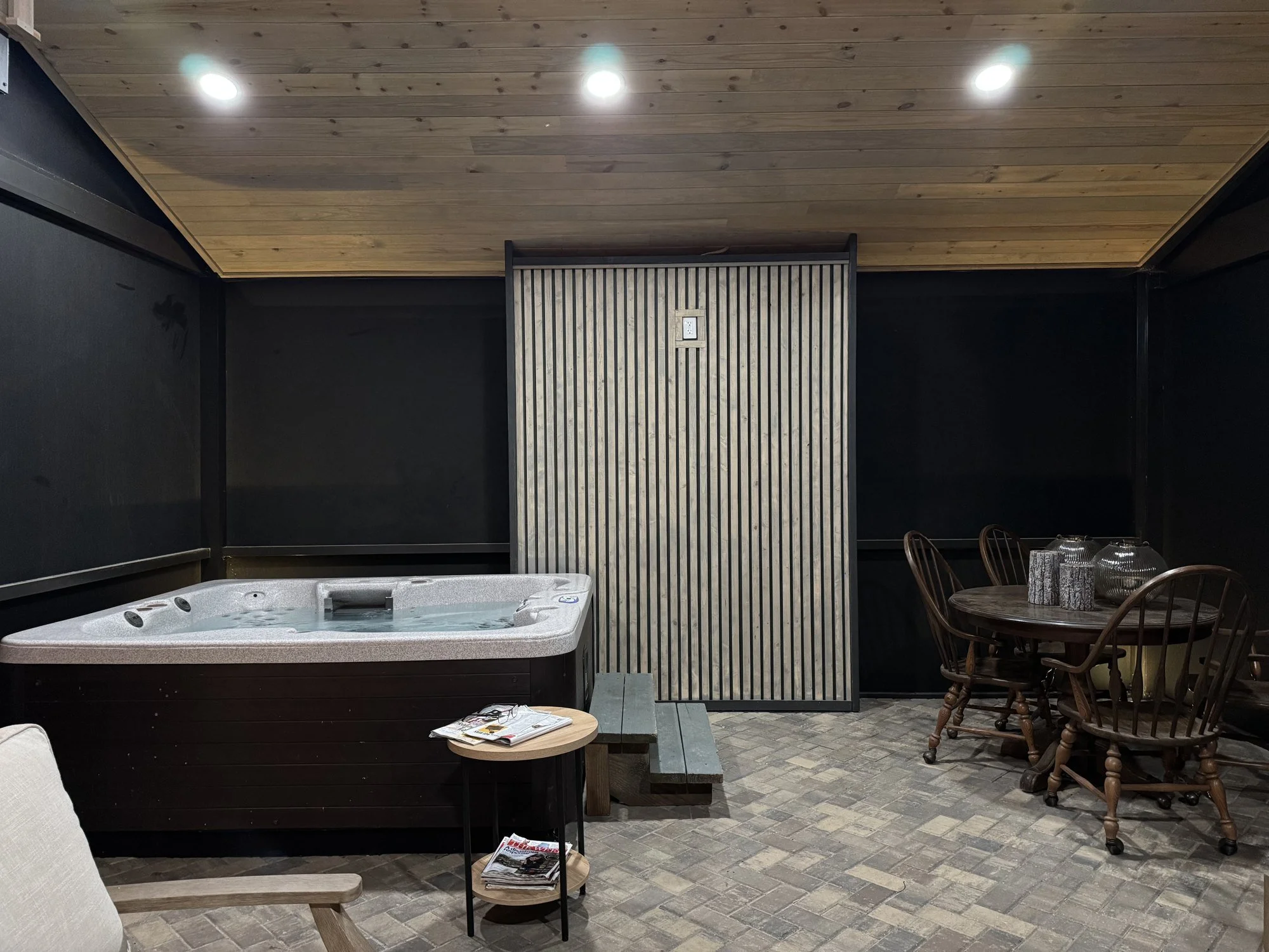 A-frame screen enclosure with a wood ceiling and hot tub pad at night in Mandarin, Jacksonville