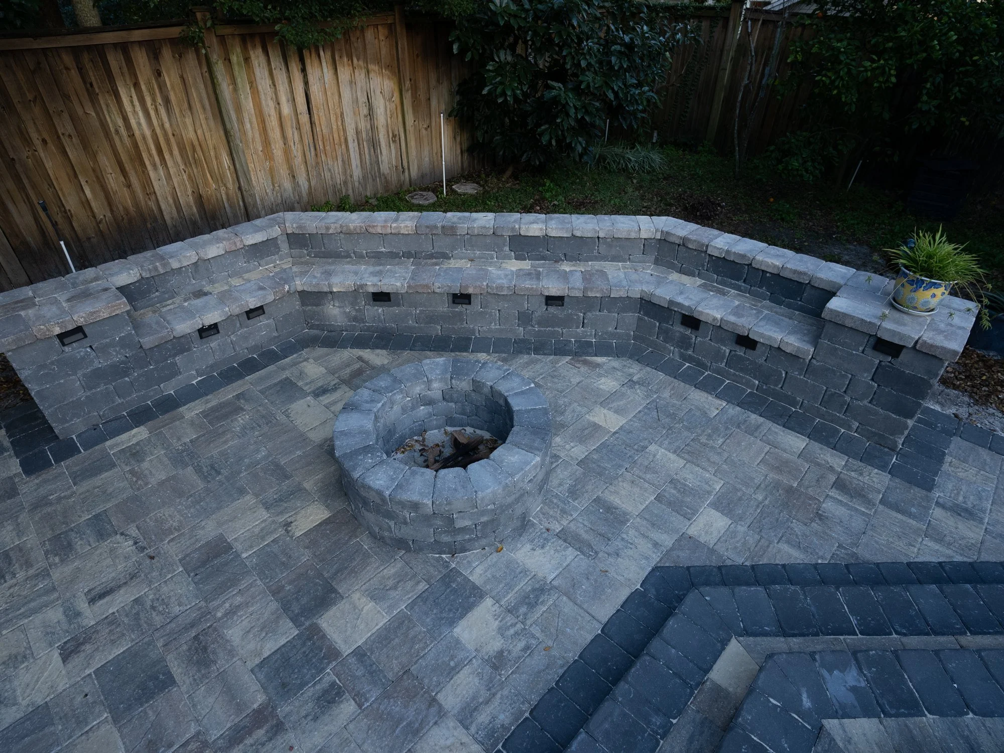 Paver patio with a lit seating wall and fire pit in Riverside, Jacksonville