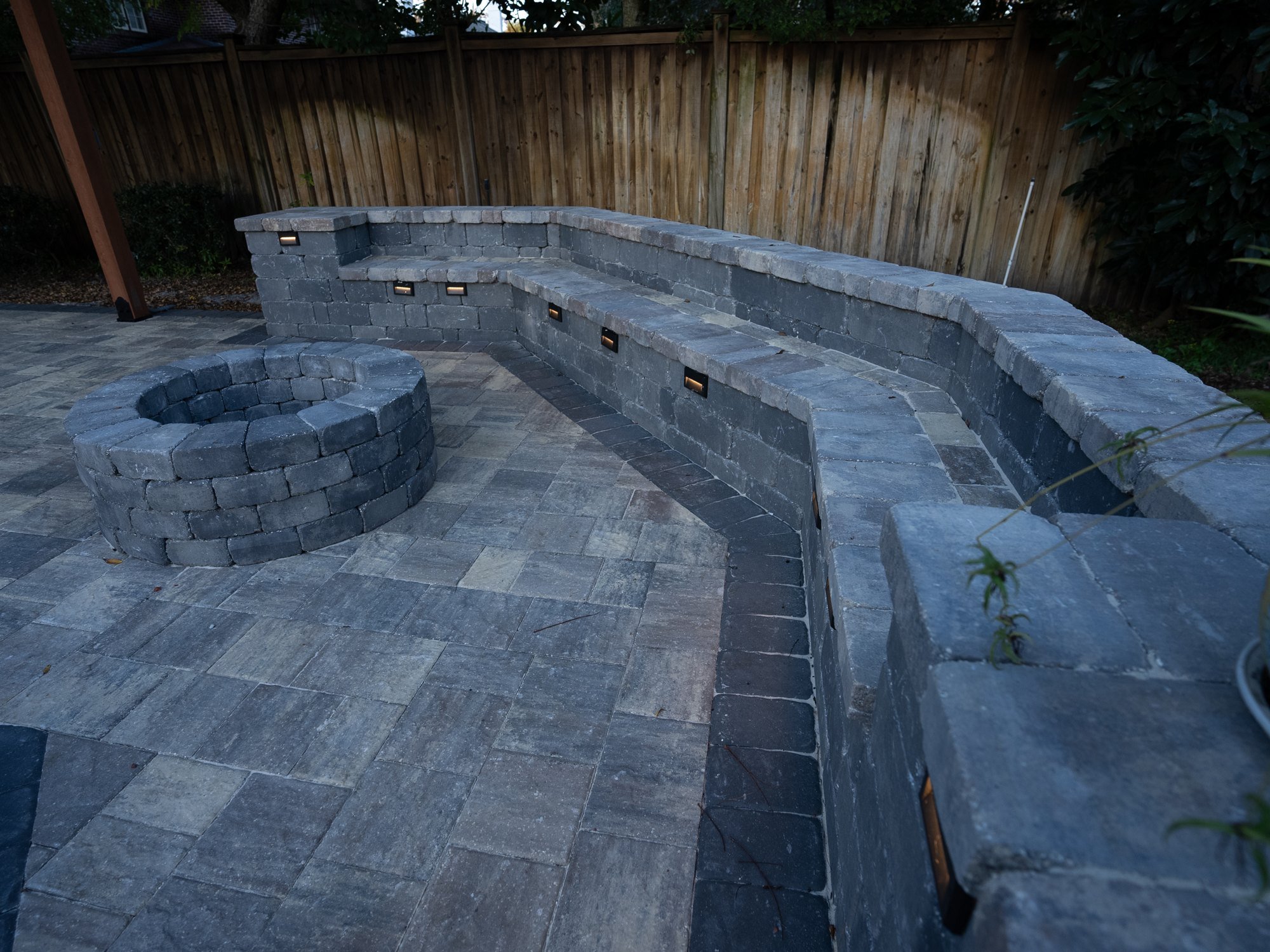 Curved seating wall around a wood-burning fire pit in Riverside, Jacksonville