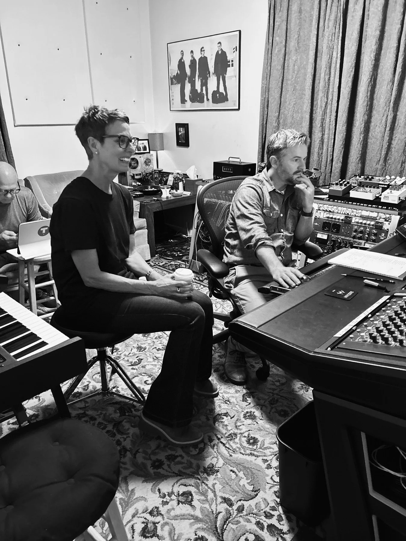 Two collaborators listening together at a studio console