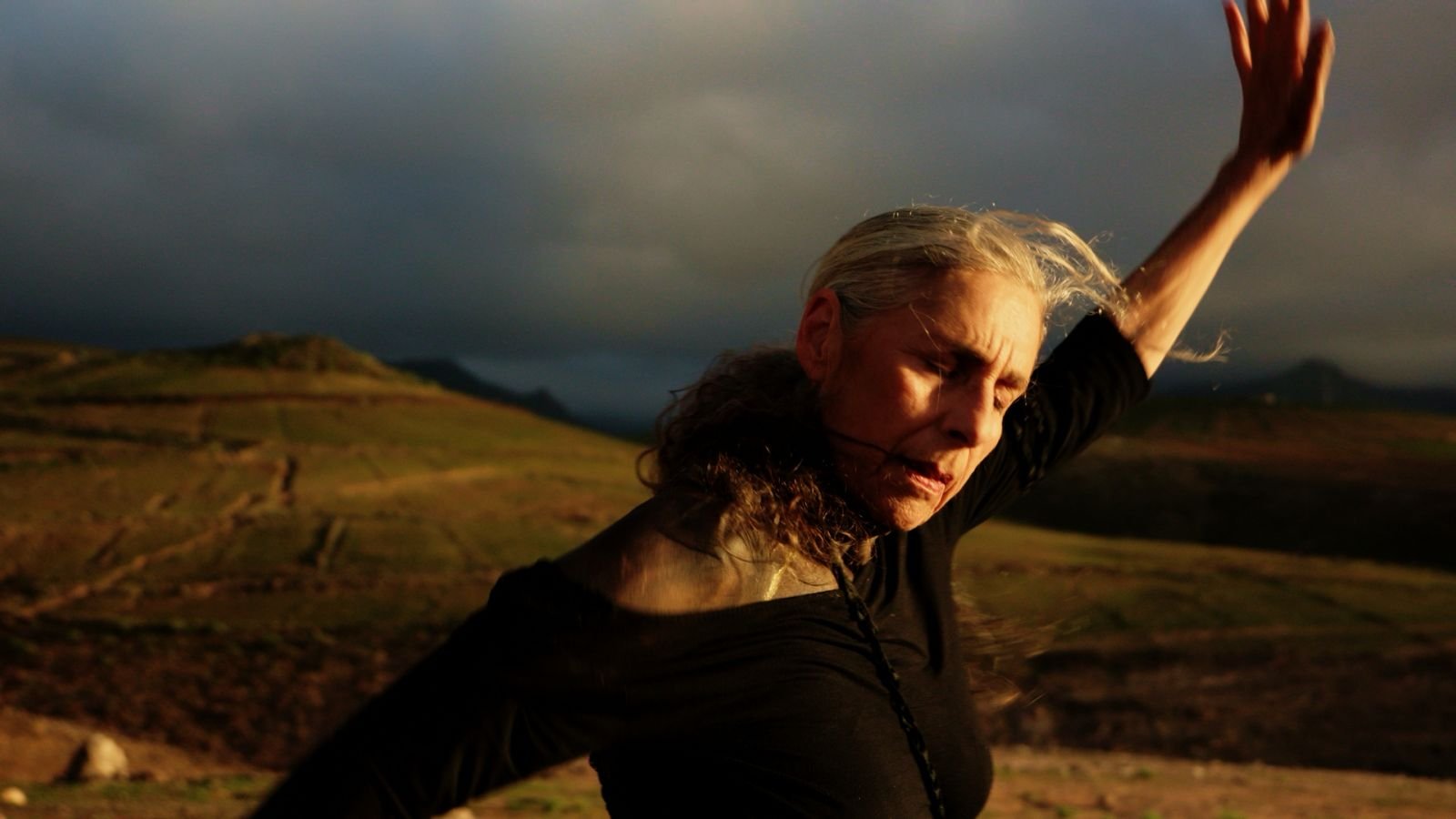 Sigrun Fritsch extending an arm against an open landscape in MISSING FACE