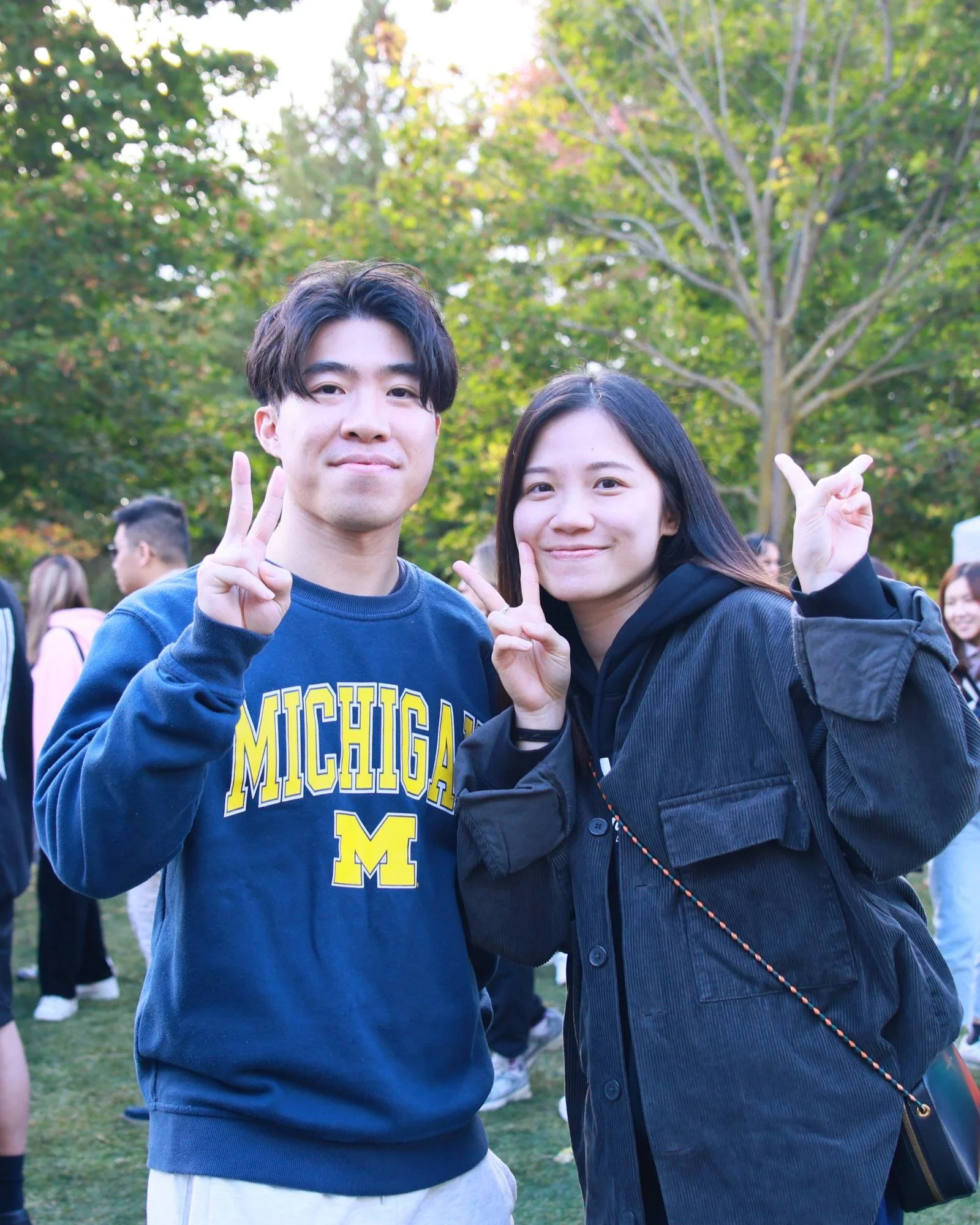 Two young visitors pose and make peace signs on the busy market lawn.