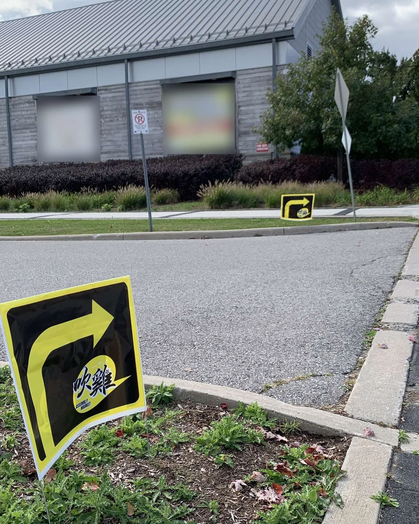 Two of the yellow arrow lawn signs in place on the Markham Museum grounds, pointing visitors along the drive.
