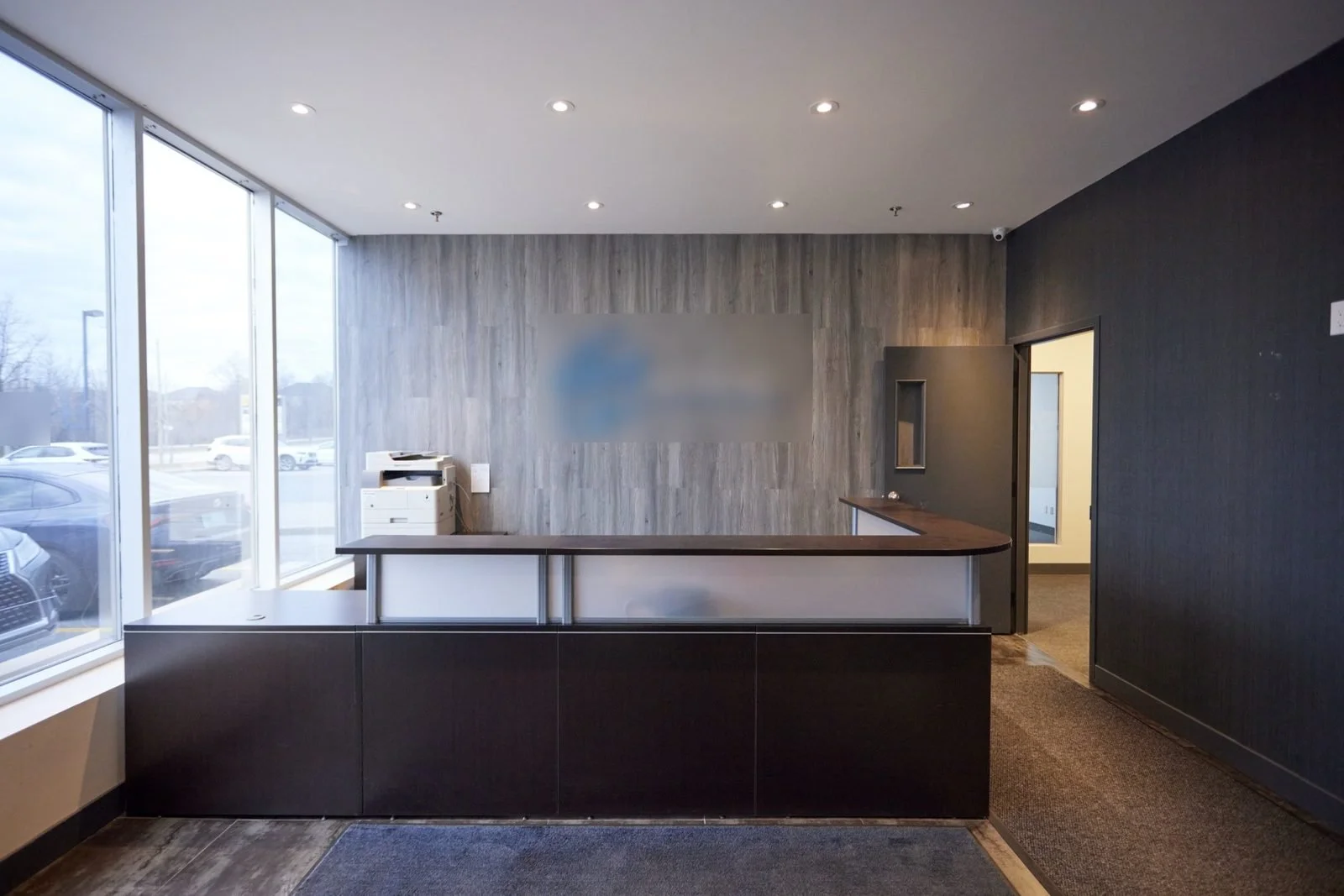 Before, March 2024: the old reception counter. The previous tenant's logo is blurred.