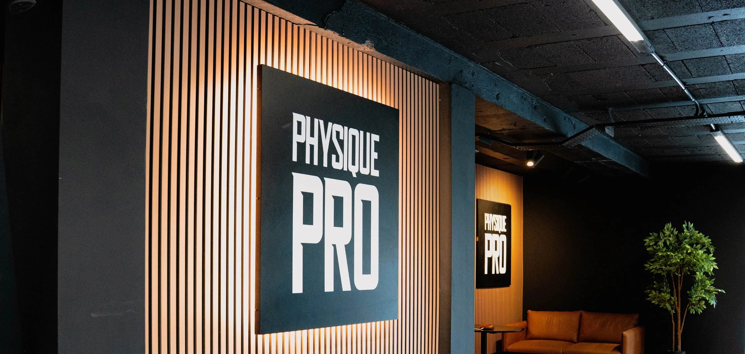 Physique Pro logo wall behind the gym floor at Ponteland