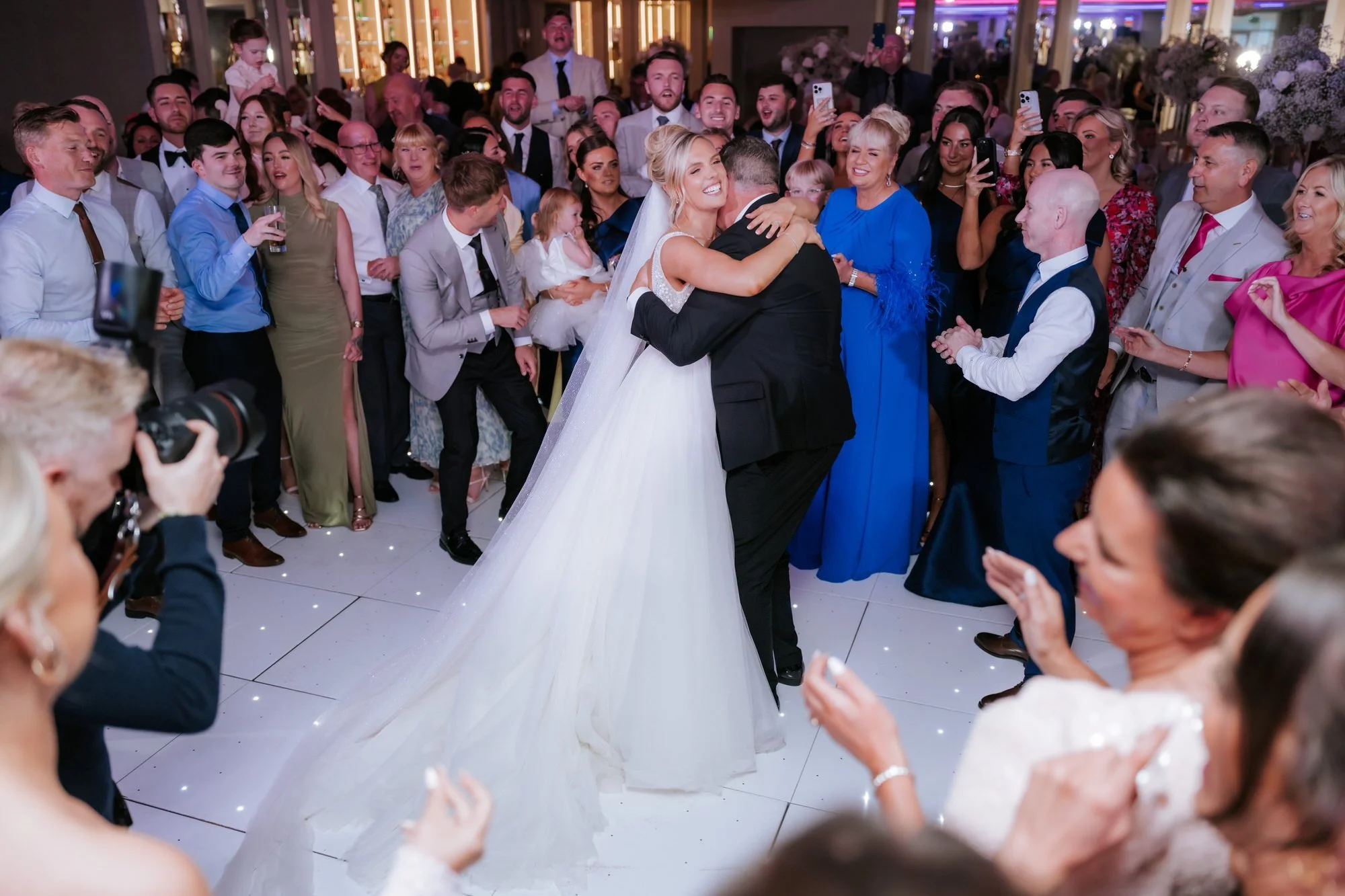 The newlyweds dancing in the centre of a circle of friends and family.