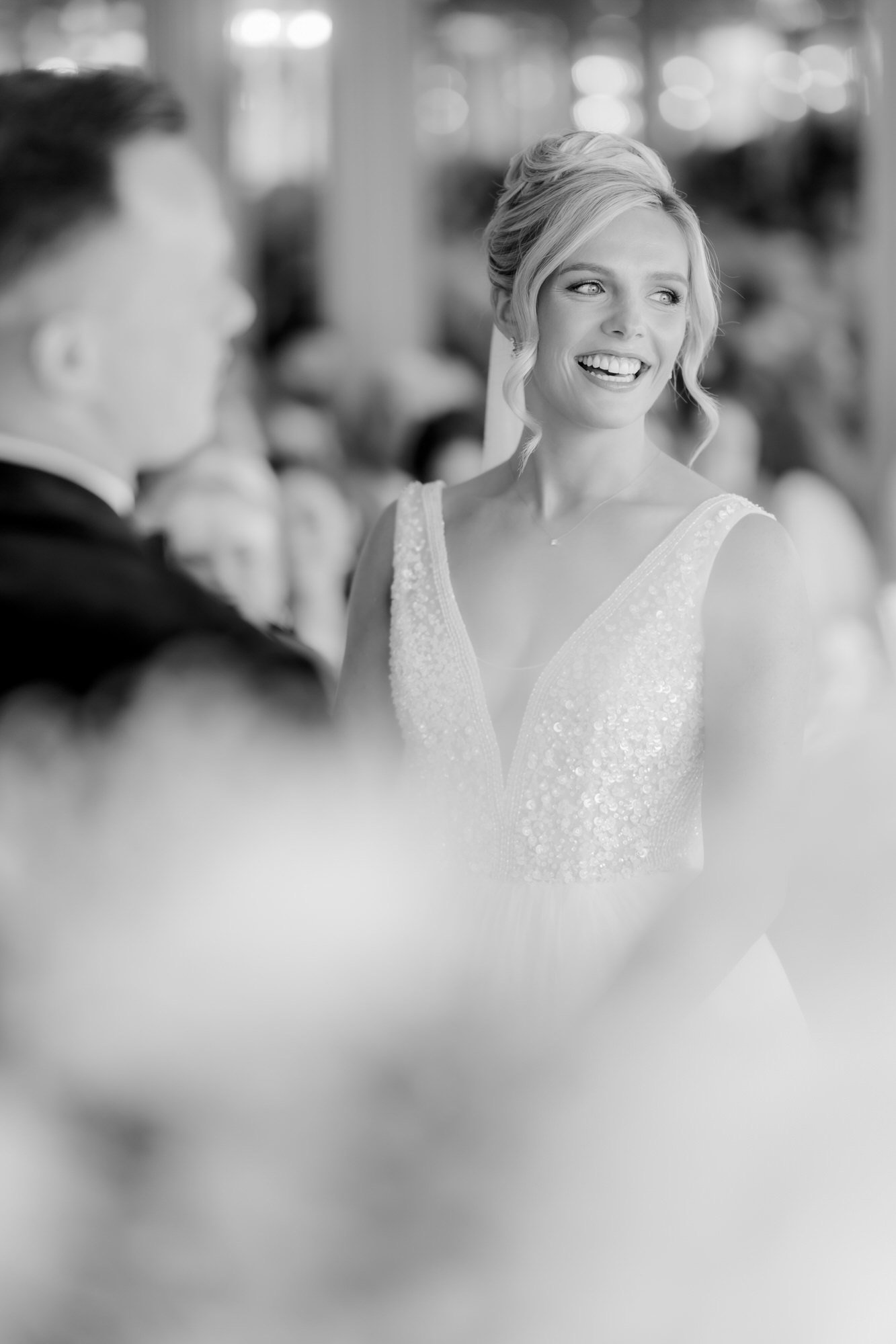 Nicole laughing during her wedding vows, photographed in black and white.