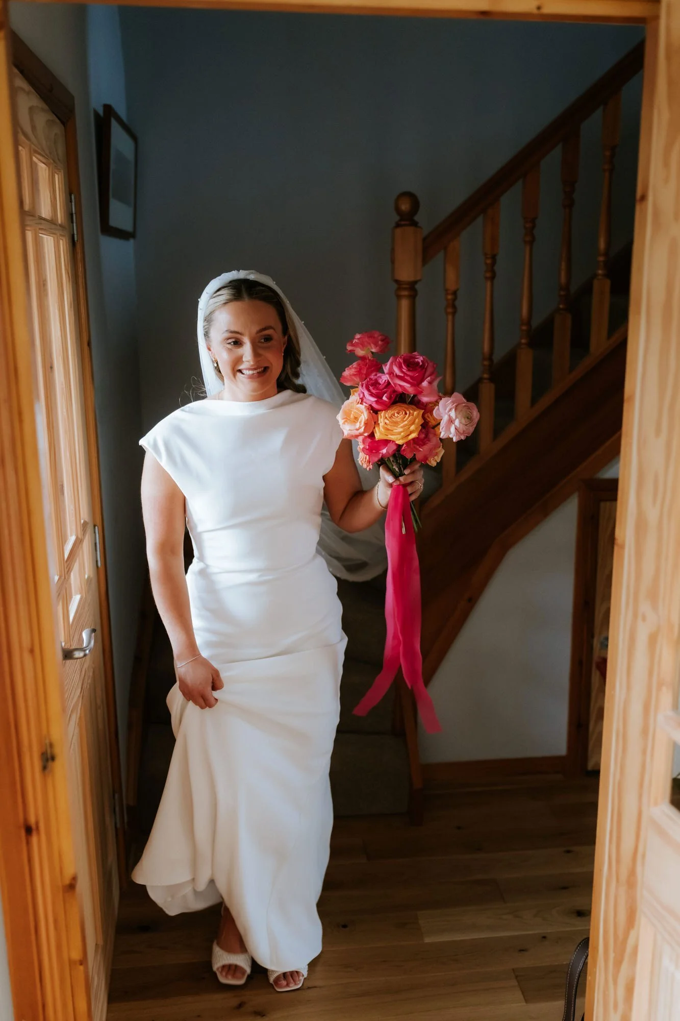 Rhona coming downstairs in her wedding dress for a first look.