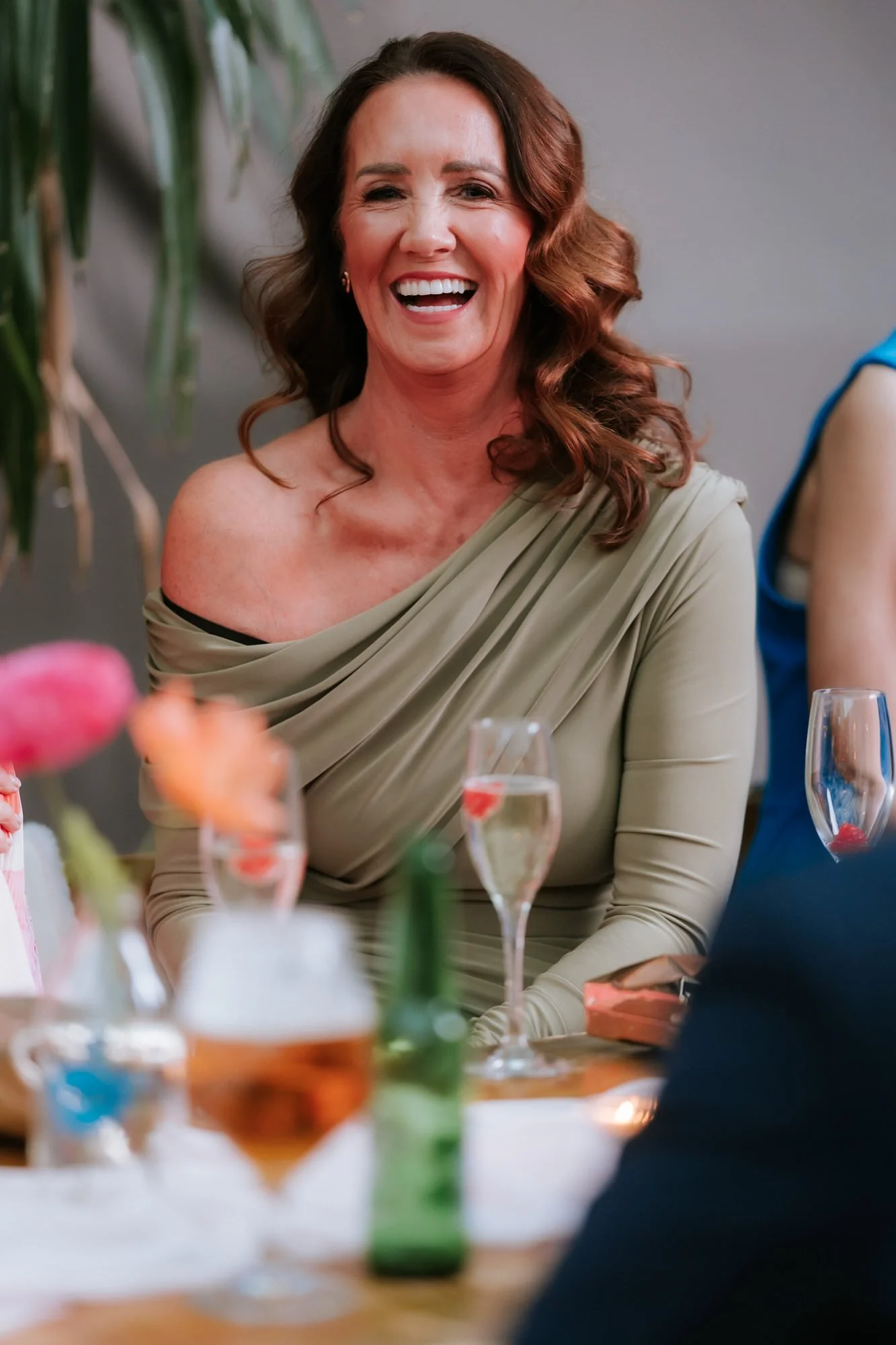 A guest in a sage dress reacting to the speeches.