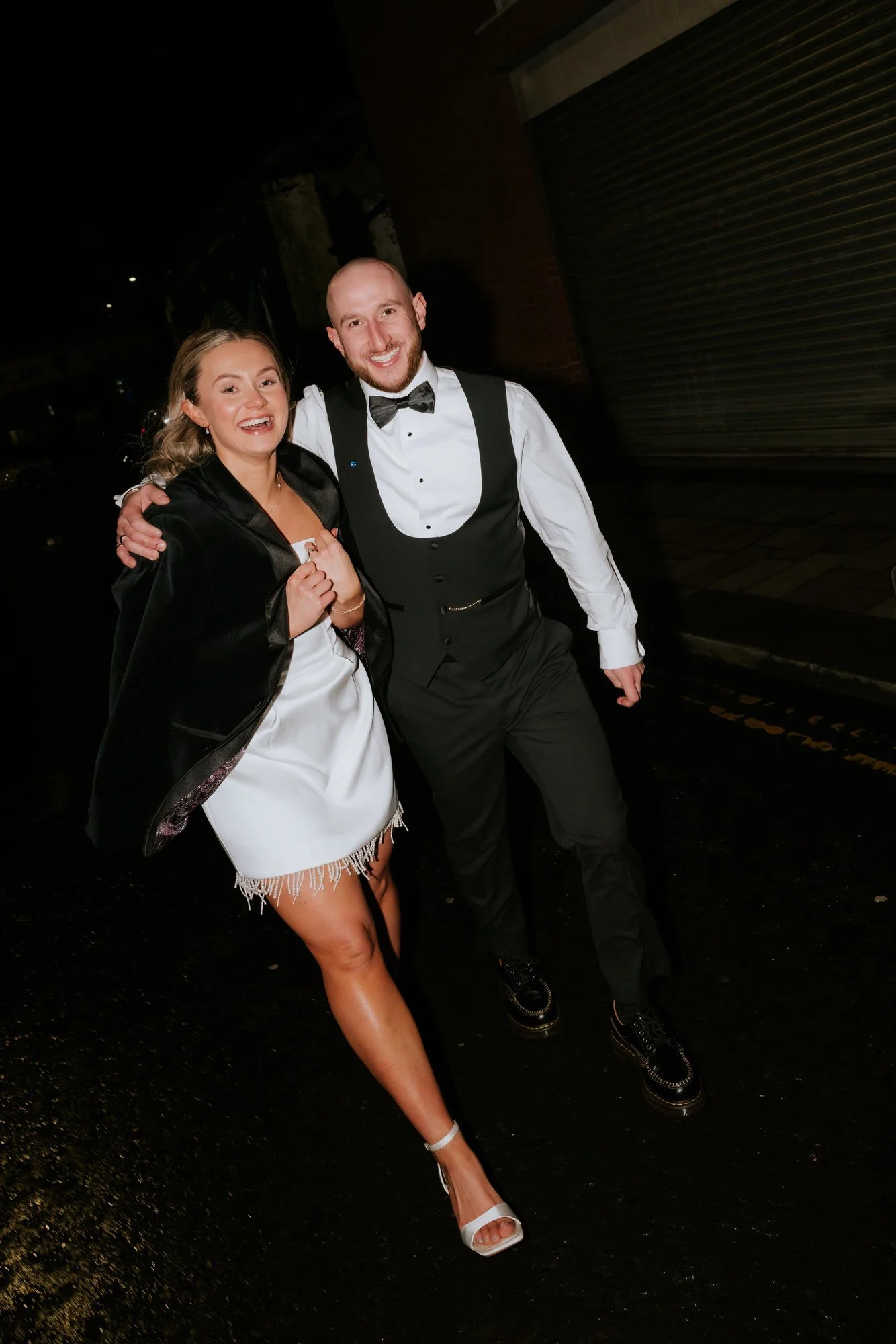 The couple walking through Glasgow at night in their evening outfits.