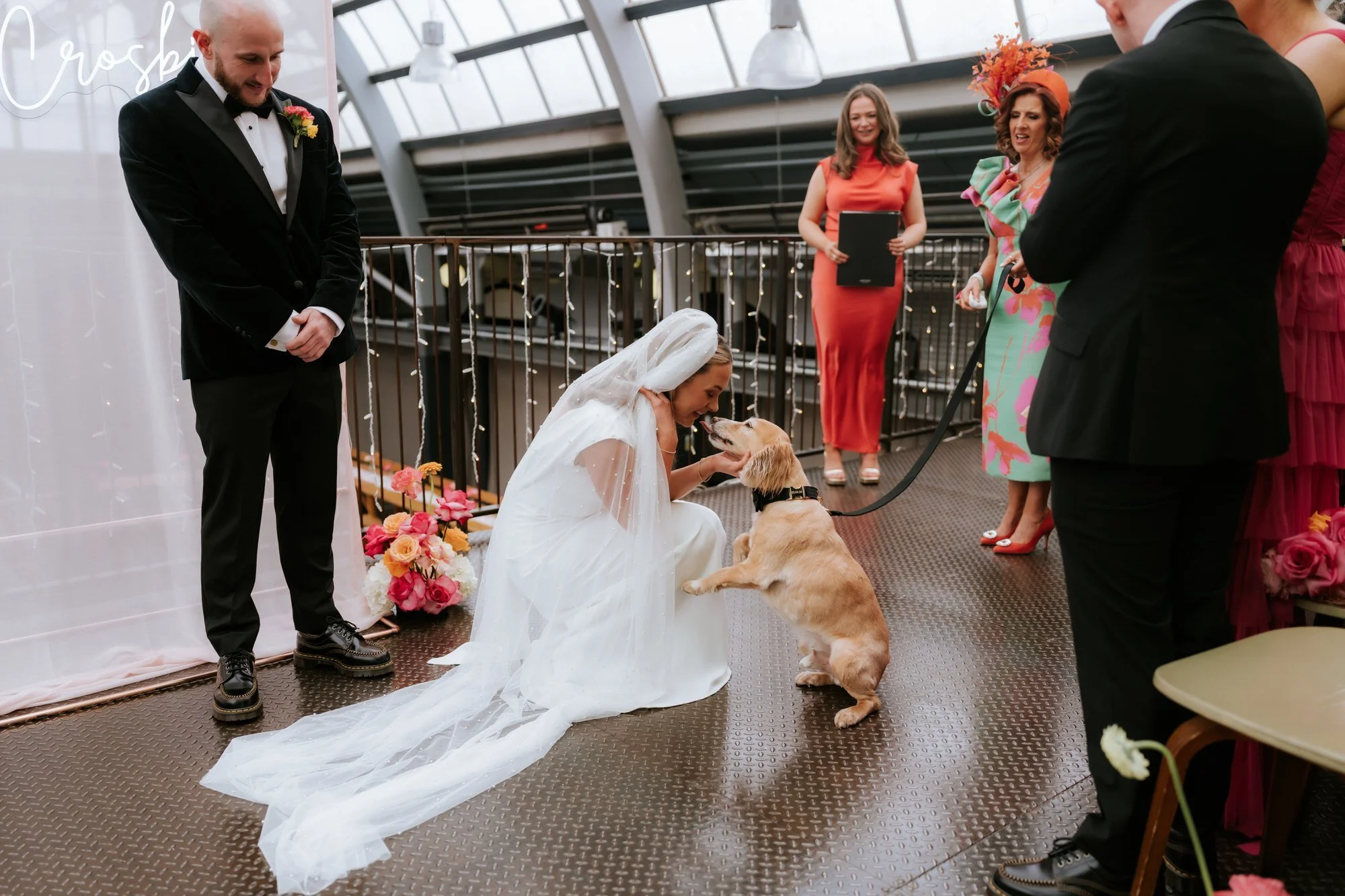 Rhona kneeling to greet the dog in the wedding aisle.