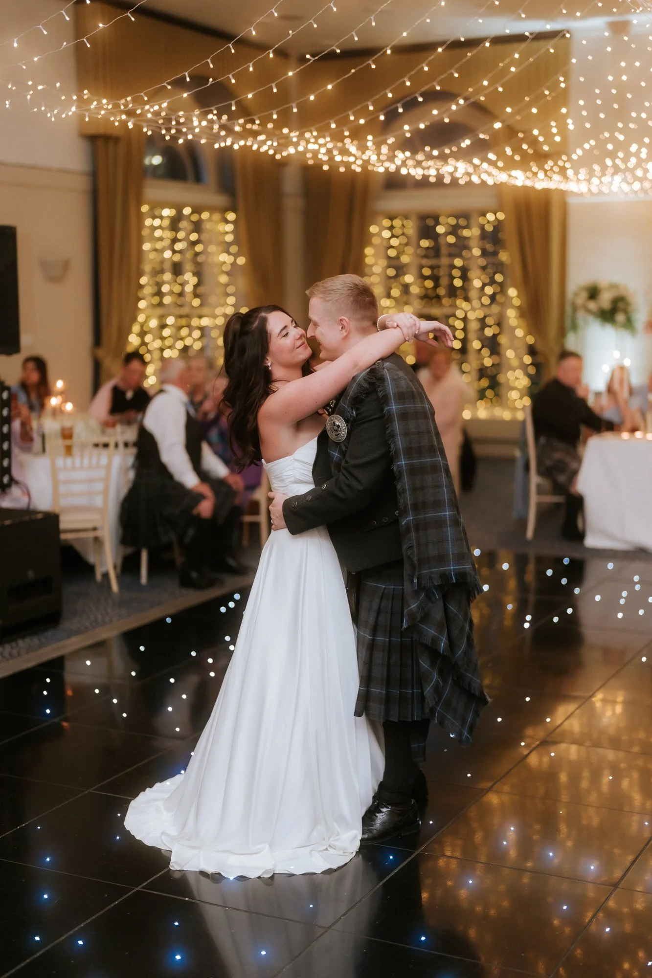 Steph and Calum's first dance beneath the reception lights.