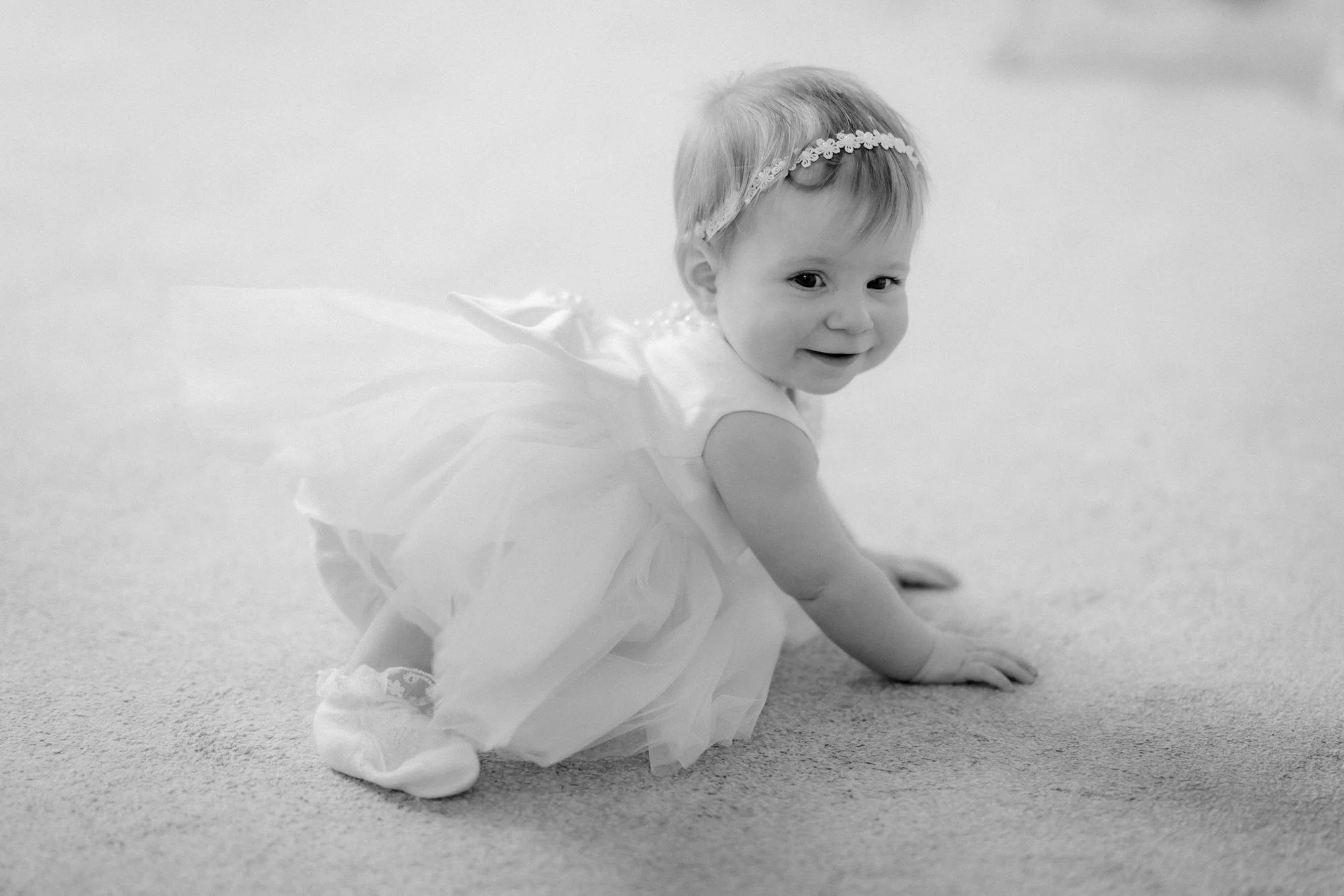 Black and white photograph of the baby crawling during the wedding.